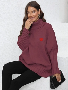 Detailed macro view of burgundy turtleneck sweater with red heart embroidery on chest
