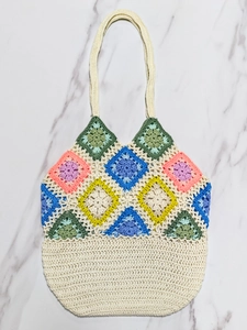 Close-up of handmade crochet granny square stitching with colorful floral patchwork