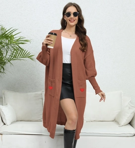 Detail of rust red knit cardigan featuring oversized pockets with red heart patches