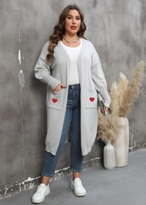 Detail of red heart embroidery on the pockets of a grey long knit cardigan for women