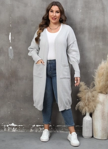 Détail du cardigan en maille gris clair avec poignets côtelés et poches avant pratiques