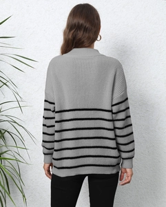 Detail view of the back of a grey striped knit sweater with ribbed cuffs and drop shoulder