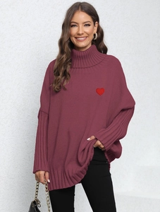 Detail of red heart embroidery on loose-fit burgundy turtleneck knitted sweater