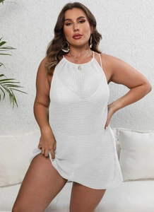 Détail du tissu en maille crochet blanc sur une robe de plage dos nu pour femme