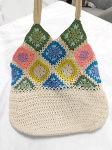 Detailed macro view of colorful granny square crochet patterns on a handmade tote bag