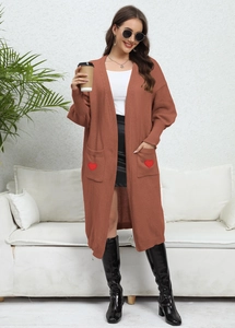 Detail showing knit cardigan pockets with heart embroidery and ribbed texture finish
