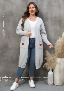 Detail of grey knitted cardigan showing red heart embroidery on the front pockets