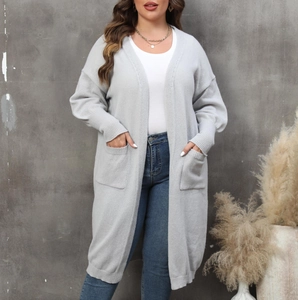Détails des grandes poches et bords-côtes sur ce cardigan en maille gris clair