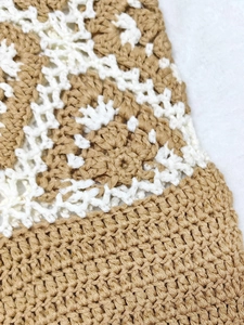 Close-up of handmade crochet shoulder bag featuring floral hollow pattern in beige