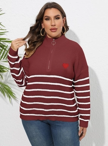 Détails de la fermeture à anneau et de la broderie cœur sur ce pull rayé bordeaux