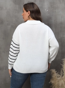 Detail view of oversized knit sweater featuring black stripes on sleeve and polo collar