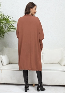 Back view of oversized rust red knitted cardigan with ribbed cuffs and loose fit