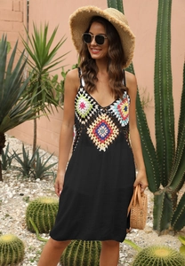 Détail du patchwork floral au crochet sur une robe de plage noire avec col en V et fines bretelles