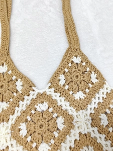 Close-up detail of crochet granny square pattern in brown and white cotton yarn