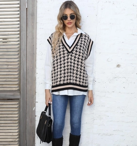 Détail d'un pull sans manches à motif pied-de-poule avec chemise et jean bleu