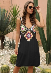 Détail du haut en crochet coloré avec col en V sur une robe d'été noire style bohème