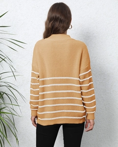 Detail view of mustard yellow knitted sweater with white stripes and cozy texture