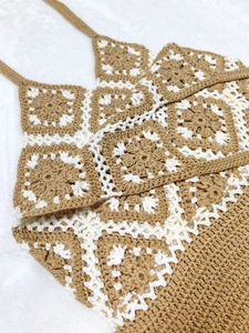 Detail view of granny square crochet crop top with tan and cream patchwork patterns