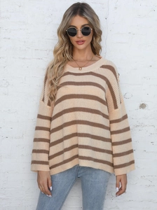 Close-up of knit texture and button detail on oversized striped sweater in almond and brown