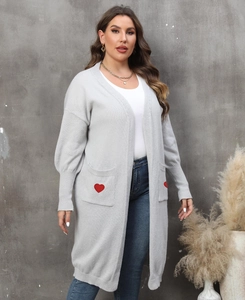 Detailed shot of grey cardigan featuring red heart embroidery on front pocket