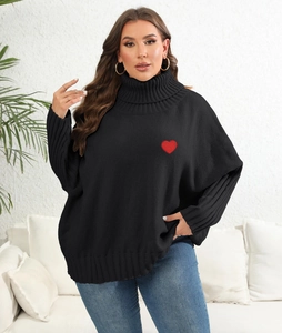 Detail of red heart embroidery on a black turtleneck sweater with ribbed knit texture