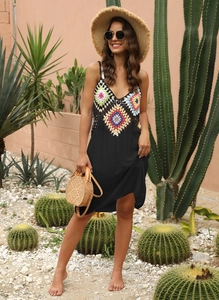 Gros plan du bustier au crochet avec des motifs floraux colorés sur la robe de plage