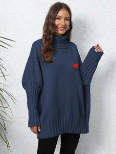 Close-up of navy knit sweater featuring a red heart patch and classic turtleneck detail