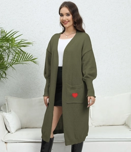 Detail of olive green cardigan featuring a red heart embroidery on the front pocket