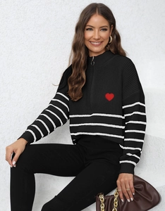 Detail of the knit sweater's half-zip collar and the red heart embroidery on the chest