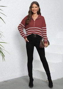 Detail of striped knit sweater featuring quarter-zip collar and casual loose fit