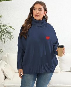 Close-up of dark blue turtleneck sweater featuring a red heart embroidery and ribbed cuffs