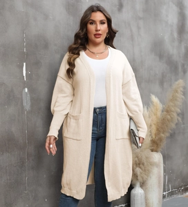 Détail d'un cardigan en maille beige avec manches lanterne et grandes poches plaquées