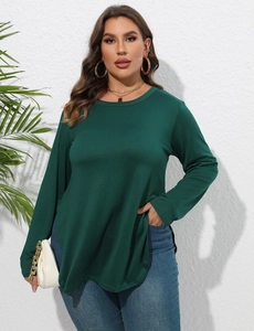 Détail d'une tunique ample vert foncé avec col rond et ourlet fendu asymétrique sur le côté