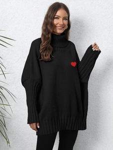Close-up of heart embroidery on women's black turtleneck oversized knit sweater