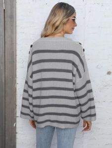Close-up of decorative brown buttons on the shoulder of a grey striped knit sweater