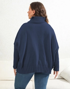 Back view of a chunky knit dark blue oversized high neck sweater with ribbed cuffs