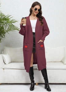 Detail view of burgundy knitted cardigan featuring heart embroidery on large front pockets