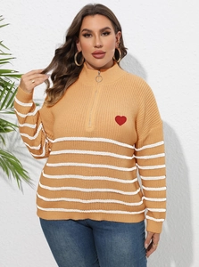 Détail d'un pull grande taille jaune gingembre avec poignets rayés et écusson cœur brodé