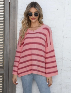 Close-up of pink striped knit sweater with drop shoulder design and textured fabric