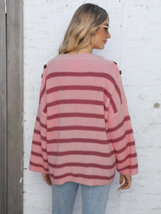 Detail view of pink striped knit sweater with shoulder buttons and drop shoulder design