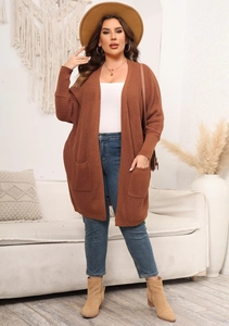Detailed knit texture of brown batwing sleeve cardigan with large pockets in cozy home setting