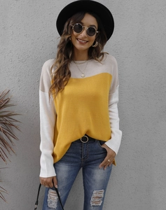 Detail of color-block knit sweater showing beige and yellow stitching texture