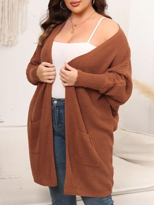 Detail of loose fit brown knit cardigan featuring large side pockets and ribbed texture