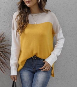 Close-up of color block knit sweater showing yellow, white and grey patchwork texture