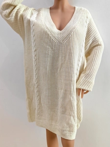 Detail of V-neck cable knit dress showing cream oversized loose fit woven texture