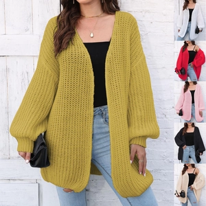 Detail of chunky knit texture and lantern sleeves on a loose mustard cardigan