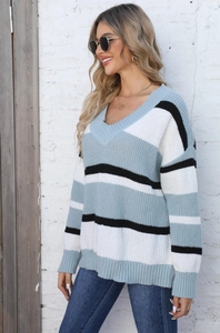 Detail of the V-neckline and soft color block striped knitting on this cozy sweater