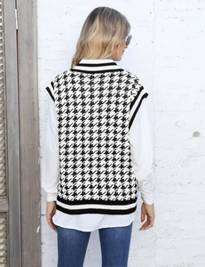 Détail de l'arrière d'un gilet en tricot pied-de-poule noir et blanc avec ourlet côtelé