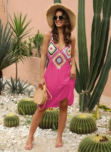 Détail du patchwork en crochet coloré sur une robe de plage dos nu rose vif