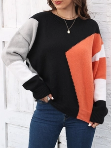 Dettaglio del maglione in maglia a blocchi di colore arancione, nero e grigio con trama